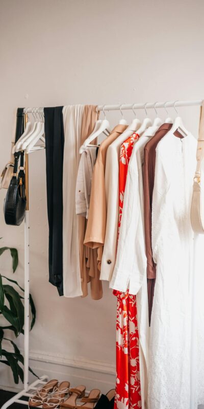 Stylish clothing rack with dresses and accessories in a boutique interior.