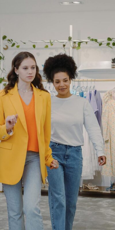 Two women exploring fashion trends in a stylish boutique together.